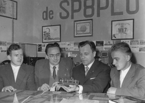 Rok 1957. W siedzibie Klubu SP8PLU. Od lewej: Tadeusz Raczek - SP8HT (SP7HT), Wiesław Wolski - SP8TM, Władysław Socha - SP8SZ i Jerzy Miśkiewicz - SP8TK. Przedmiotem zainteresowania jest klucz telegraficzny tz. bug, który wykonał SP8SZ.